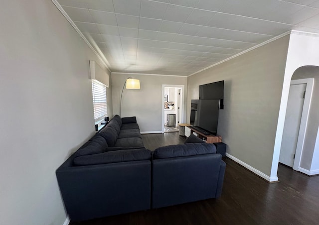 living room featuring arched walkways, dark wood-style flooring, baseboards, and ornamental molding