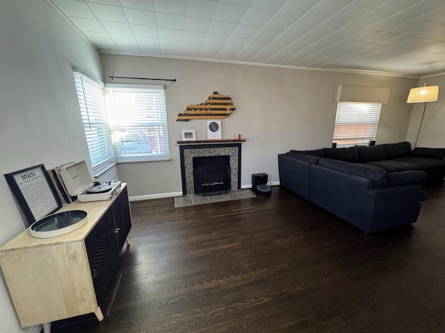 living room with baseboards, a fireplace, dark wood finished floors, and crown molding