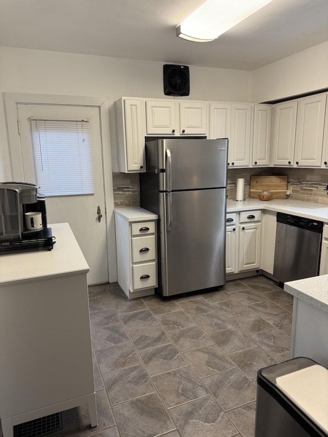 kitchen with visible vents, tasteful backsplash, stainless steel appliances, white cabinets, and light countertops