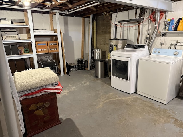 unfinished below grade area featuring water heater and separate washer and dryer