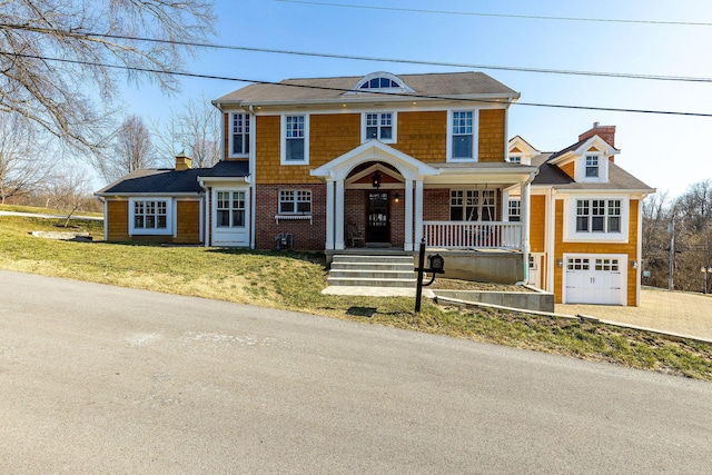 view of front facade featuring a porch, an attached garage, and a chimney