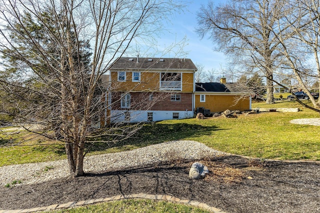 back of house featuring a lawn and a chimney