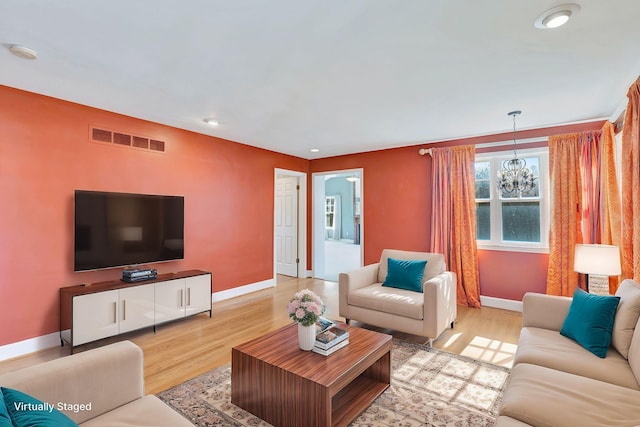 living room featuring baseboards, visible vents, recessed lighting, light wood-style floors, and a chandelier