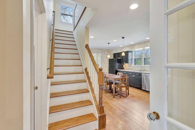 stairway with recessed lighting, a skylight, and wood finished floors