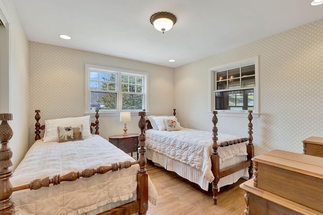 bedroom with recessed lighting, multiple windows, wood finished floors, and wallpapered walls