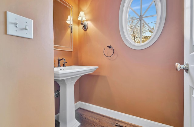 bathroom featuring baseboards and a sink