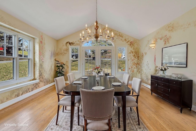 dining space with light wood-style floors, vaulted ceiling, and wallpapered walls