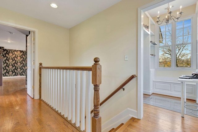 stairs featuring a chandelier, recessed lighting, baseboards, and wood finished floors