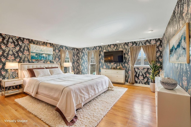 bedroom featuring wallpapered walls, light wood-type flooring, and baseboards