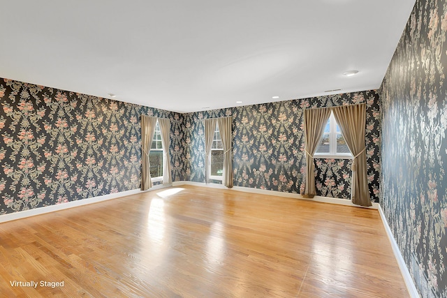 unfurnished room featuring wallpapered walls, light wood-style flooring, and baseboards