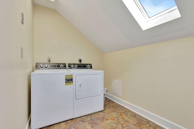 laundry area featuring washer and dryer, laundry area, a skylight, and baseboards