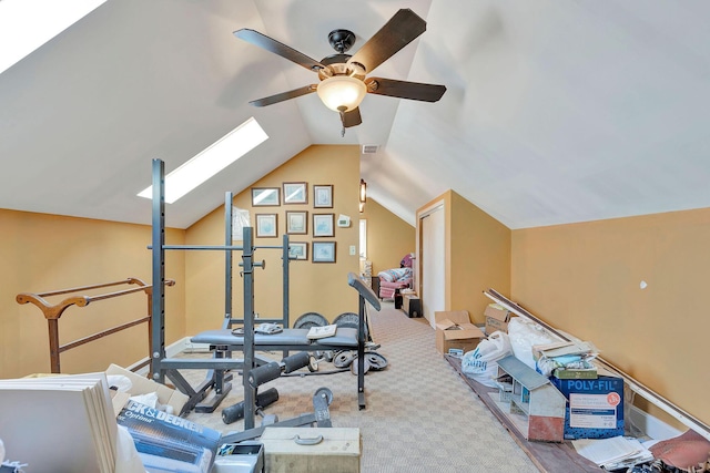 exercise room with lofted ceiling with skylight, carpet flooring, and visible vents