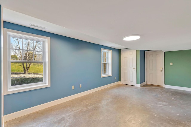 unfurnished room featuring visible vents, baseboards, and concrete floors