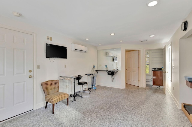 sitting room with recessed lighting, a wall mounted air conditioner, speckled floor, and baseboards