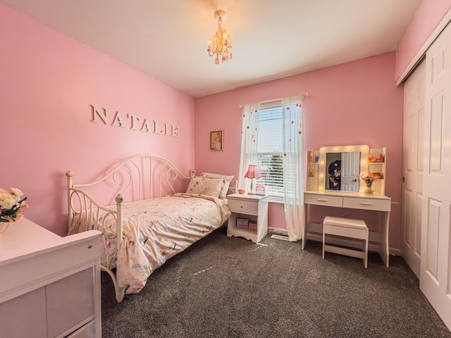 carpeted bedroom featuring a closet and a chandelier