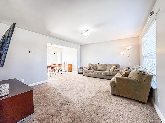 carpeted living room featuring baseboards