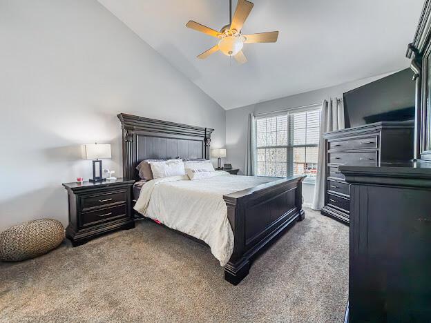 carpeted bedroom with high vaulted ceiling and a ceiling fan