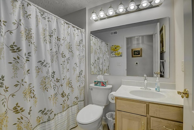 bathroom featuring visible vents, toilet, vanity, a shower with curtain, and a textured ceiling