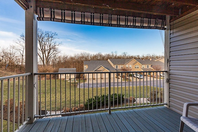 wooden deck featuring a yard and a residential view