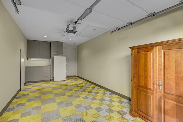 garage featuring baseboards, recessed lighting, freestanding refrigerator, ceiling fan, and a garage door opener