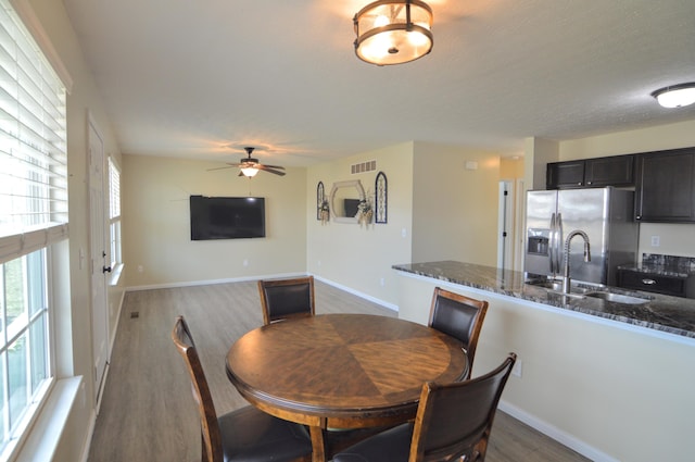 dining area with visible vents, a ceiling fan, a textured ceiling, wood finished floors, and baseboards