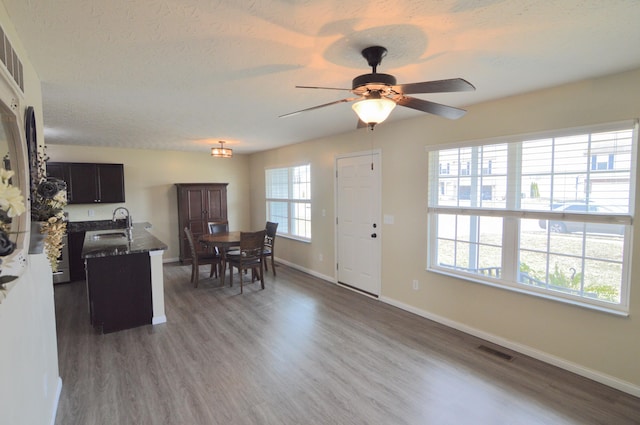 kitchen featuring dark wood-type flooring, baseboards, visible vents, and a textured ceiling