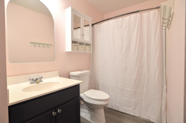 full bathroom with curtained shower, toilet, wood finished floors, and vanity