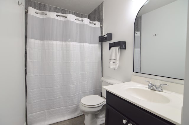 bathroom featuring curtained shower, toilet, wood finished floors, and vanity