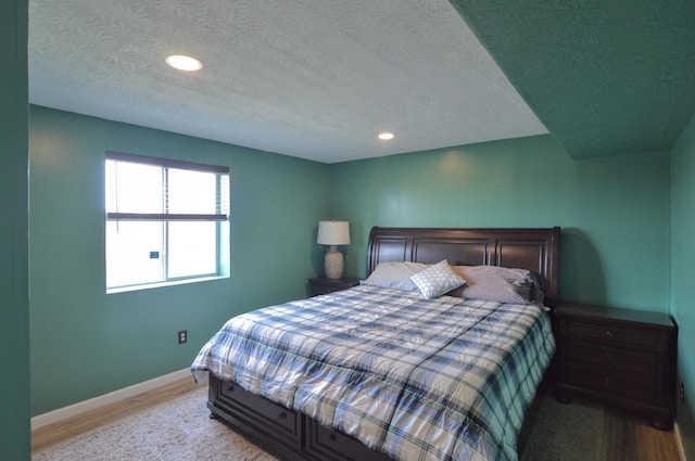 bedroom featuring recessed lighting, baseboards, a textured ceiling, and wood finished floors