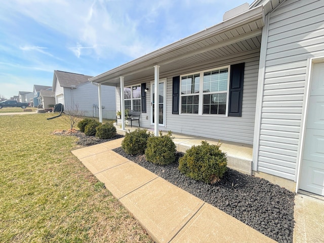 entrance to property featuring a porch and a yard