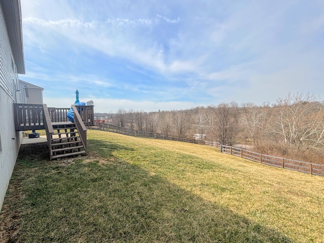 view of yard featuring a rural view, stairs, a deck, and fence