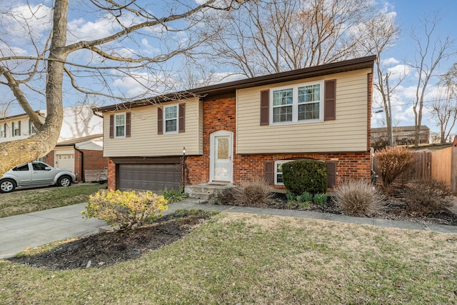 bi-level home with brick siding, driveway, an attached garage, and a front lawn