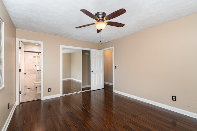 unfurnished bedroom featuring baseboards, ensuite bathroom, hardwood / wood-style flooring, a closet, and a textured ceiling