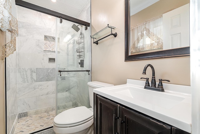 full bathroom with vanity, a shower stall, and toilet