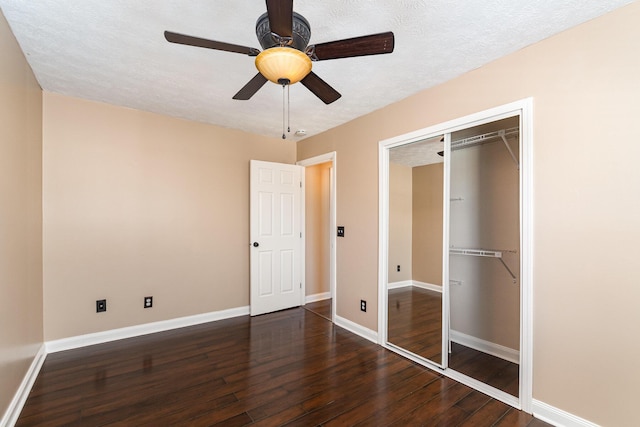 unfurnished bedroom with a closet, baseboards, wood-type flooring, and a textured ceiling