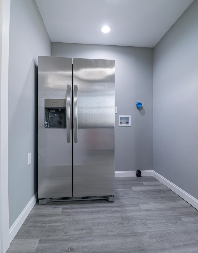 room details featuring baseboards, stainless steel fridge, and wood finished floors