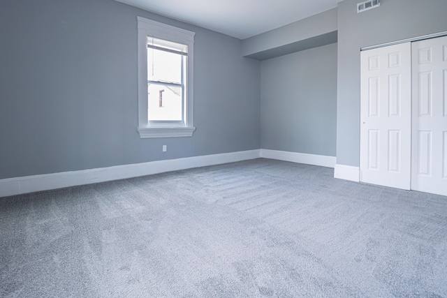 unfurnished bedroom with visible vents, carpet flooring, baseboards, and a closet