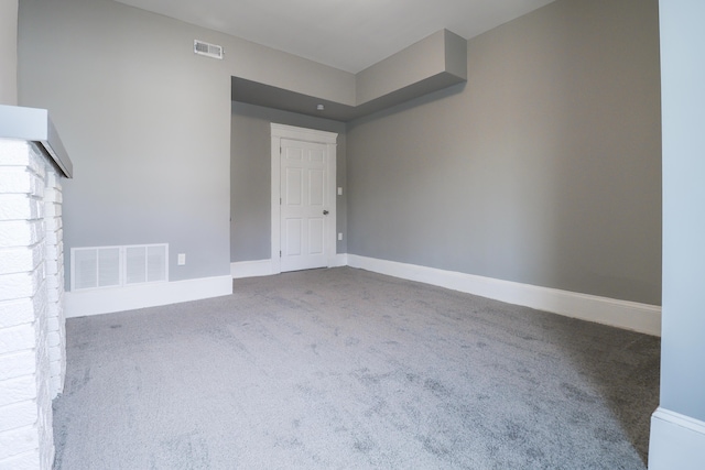 carpeted spare room featuring baseboards and visible vents