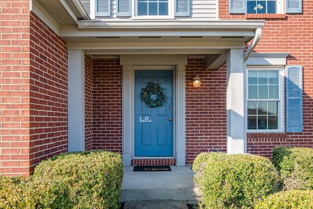 doorway to property with brick siding