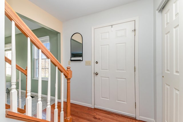 entryway with stairway, baseboards, and wood finished floors