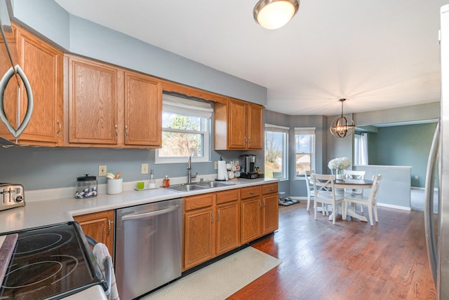 kitchen featuring a sink, light countertops, an inviting chandelier, and stainless steel dishwasher