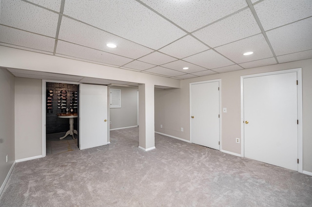 finished basement with carpet flooring, recessed lighting, baseboards, and a paneled ceiling