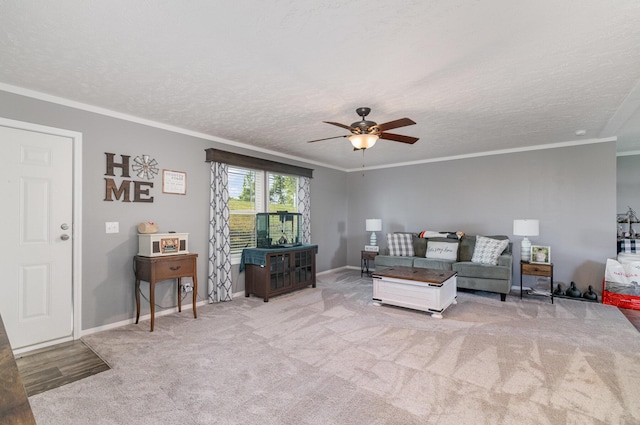 carpeted living area featuring baseboards, a textured ceiling, a ceiling fan, and ornamental molding