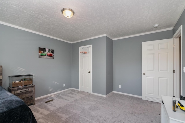 bedroom with a textured ceiling, crown molding, baseboards, and carpet floors