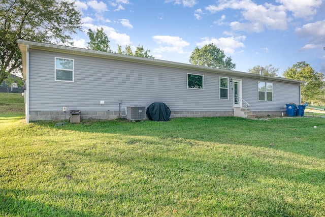 back of house with crawl space, central air condition unit, entry steps, and a yard