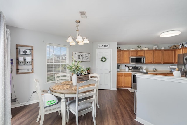 dining area featuring dark wood finished floors, visible vents, baseboards, and an inviting chandelier