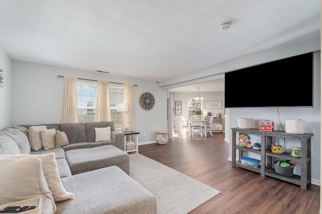 living area with dark wood-style floors, visible vents, baseboards, and an inviting chandelier