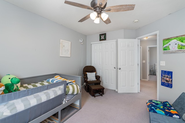 bedroom featuring a ceiling fan, a closet, and light carpet