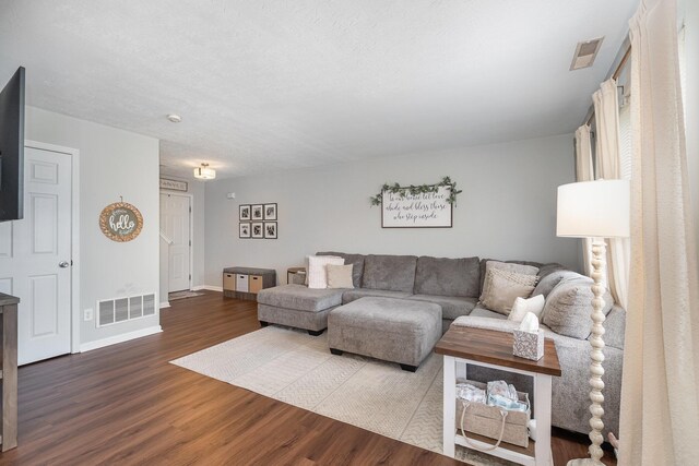 living area featuring wood finished floors, visible vents, and baseboards