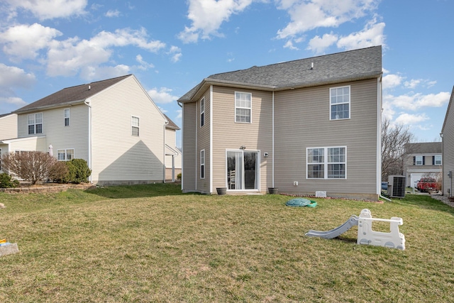 rear view of house with a yard and central air condition unit